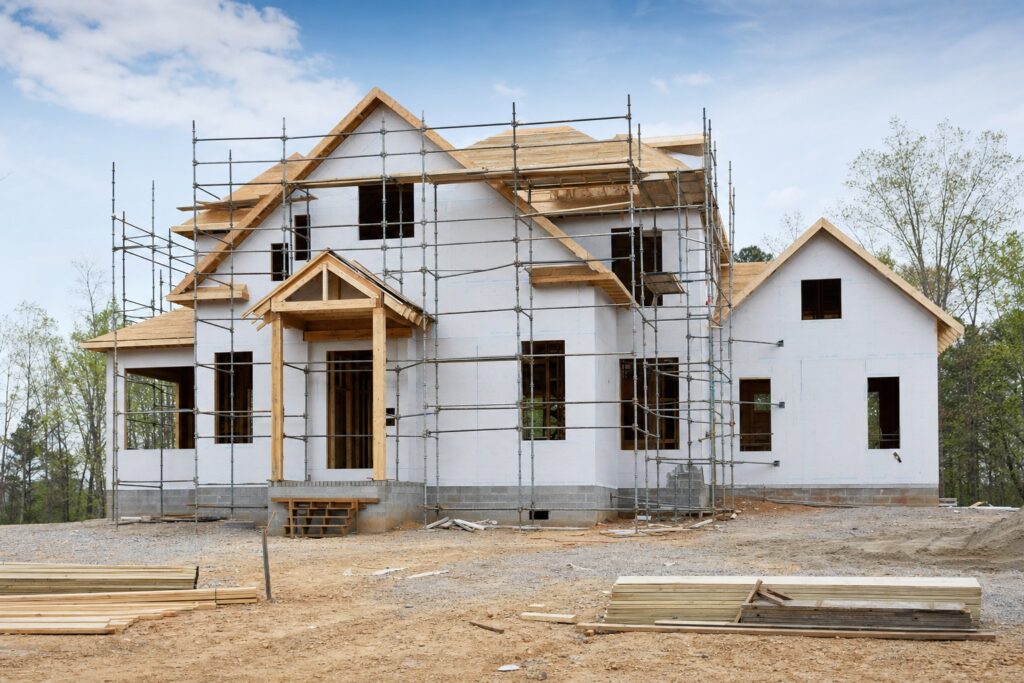 Custom home mid-construction, framed and wrapped with scaffolding - Valor Builder